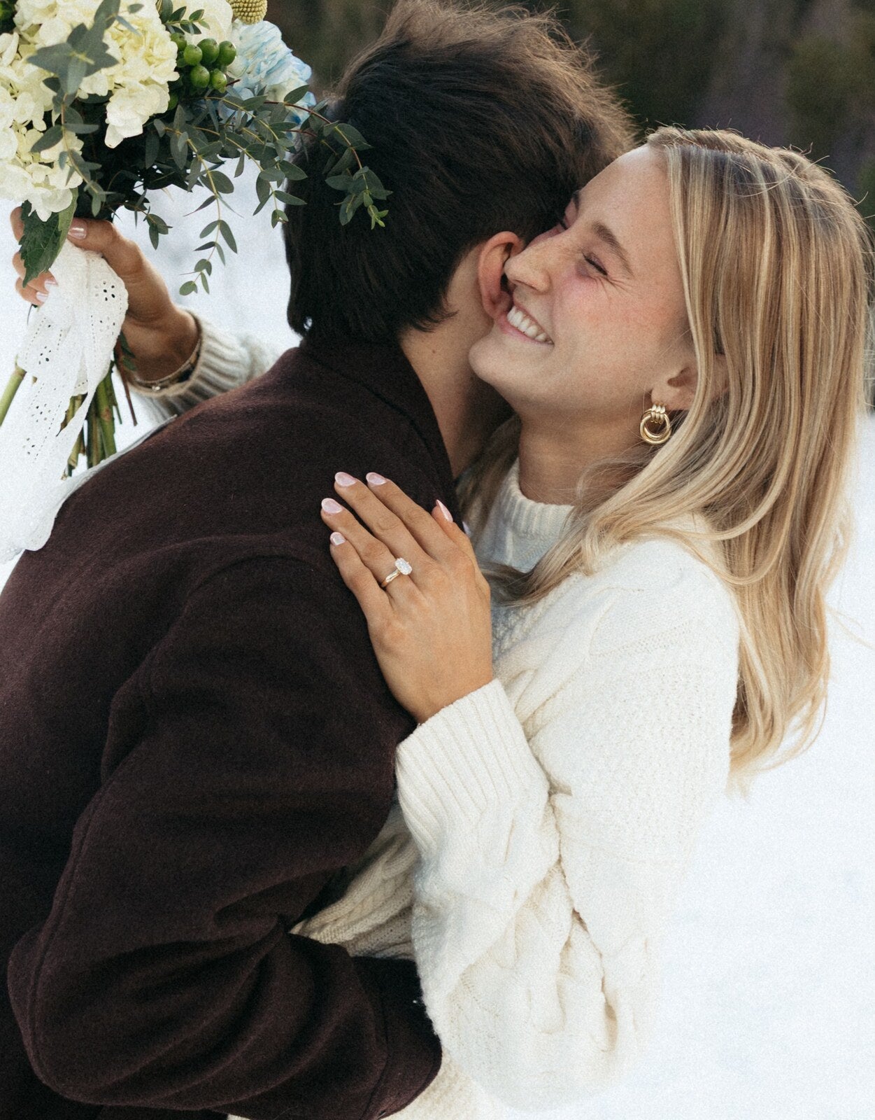 A real Lavora couple embracing, her engagement ring in view